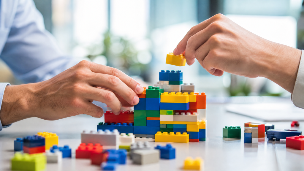 Manos construyendo con piezas de armar en un taller de creatividad